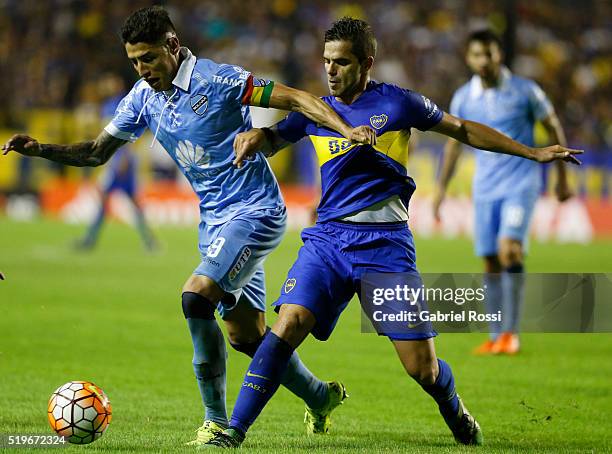 Nelson Cabrera of Bolivar fights for the ball with Fernando Gago of Boca Juniors during a match between Boca Juniors and Bolivar as part of Group 3...