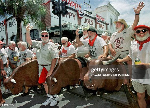 Ernest Hemingway look-alikes "run" with fake bulls, 22 July 2000, during Key West's annual Hemingway Days Festival that concludes 23 July. The event,...