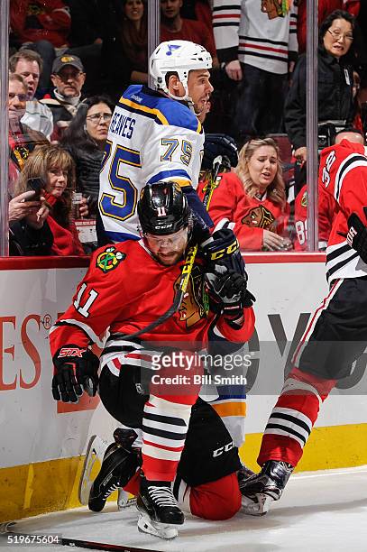 Ryan Reaves of the St. Louis Blues and Andrew Desjardins of the Chicago Blackhawks get physical by the boards in the first period of the NHL game at...