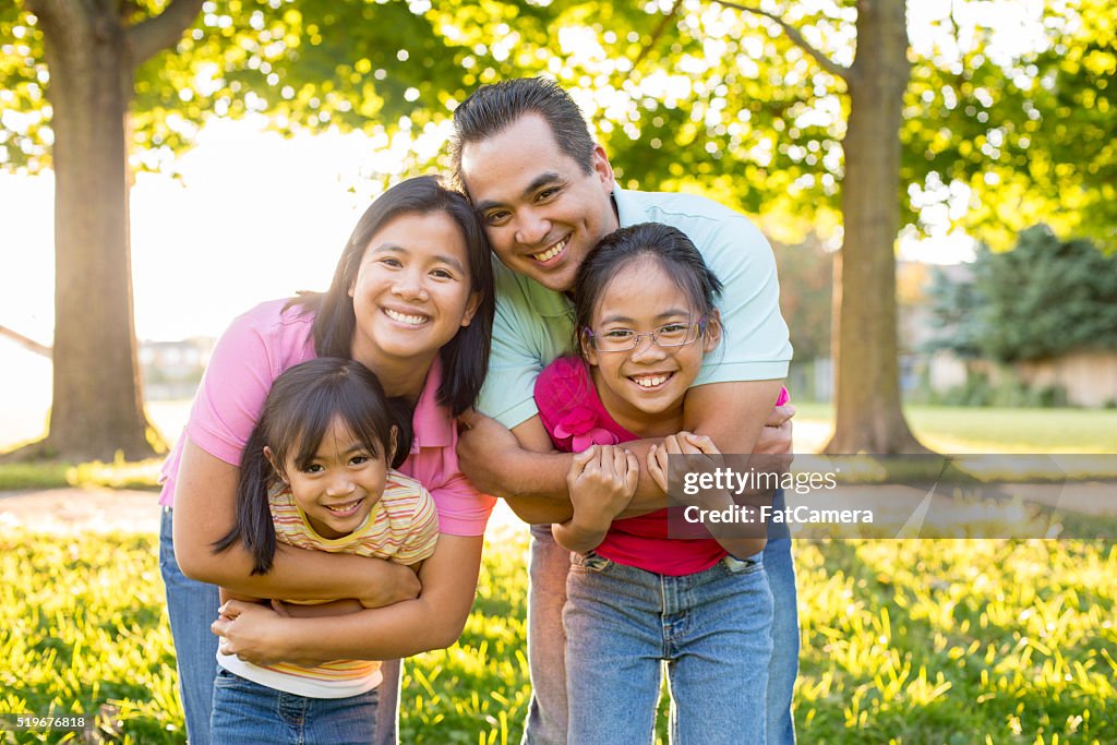 A family of four is hanging out together in the park