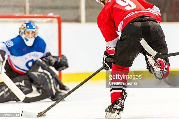men playing ice hockey - hockey net stock pictures, royalty-free photos & images