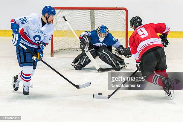 uomini giocando hockey su ghiaccio - hockey su ghiaccio foto e immagini stock