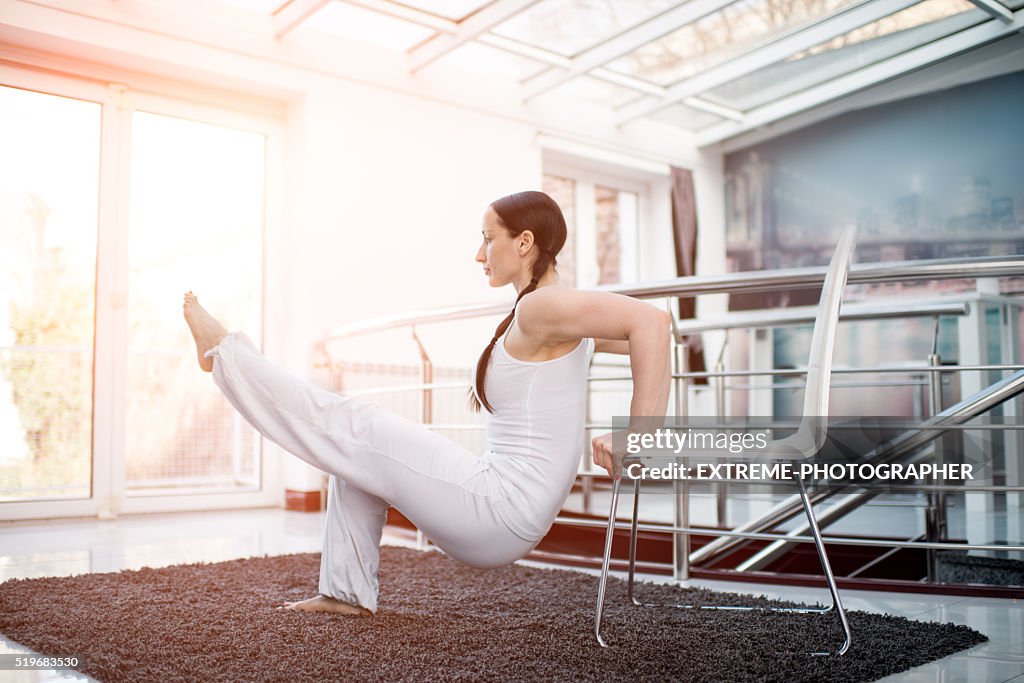 Mulher em branco exercer com uma cadeira