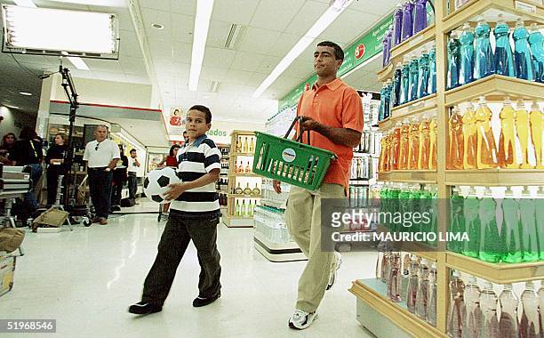 Brazilian soccer player Romario makes a commercial with a child in a supermarket in San Pablo, Brazil 09 October 2000. El jugador de la seleccion...