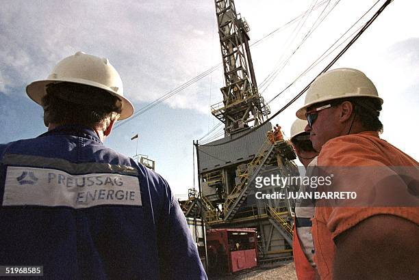 Petroleum workers inspectsa drill system in Maracaibo, Venezuela, about 800 miles west of Caracas, 22 September 2000. Venezuelan petroleum workers...