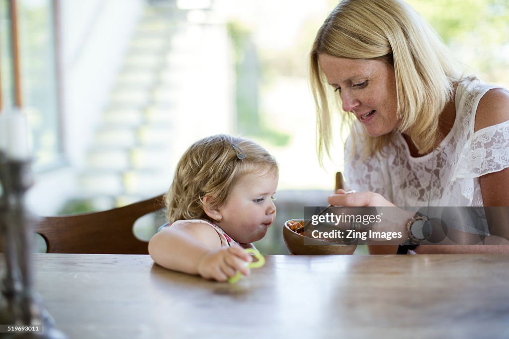 Mother feeding daughter