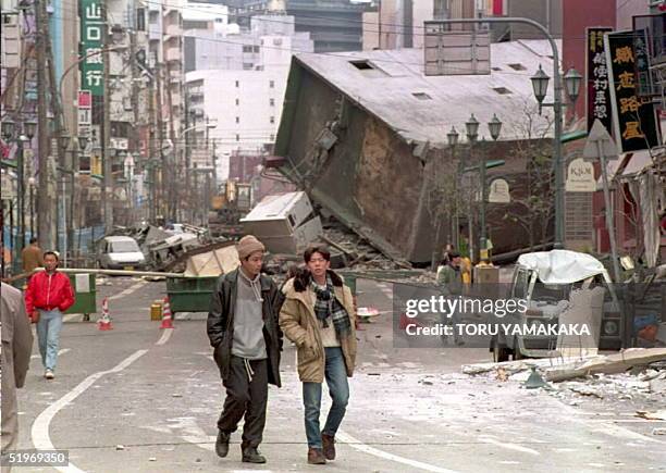 Collapsed building blocks the main street of central Kobe 18 January after a powerful earthquake measuring 7.2 on the Richter scale struck western...