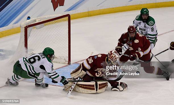 Denver Pioneers goalie Tanner Jaillet makes a save on a shot by North Dakota Fighting Hawks forward Brock Boeser with some help from Denver Pioneers...