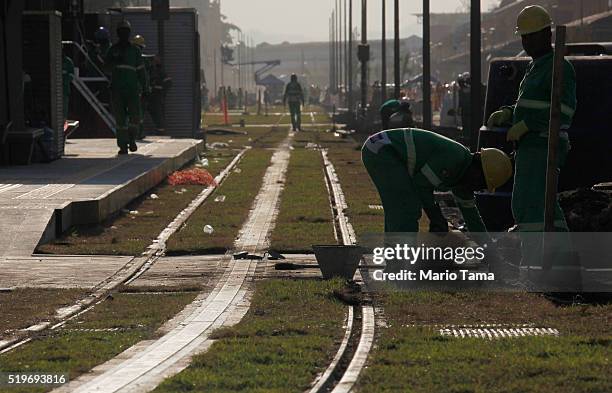 Workers lay grass along a line of the new VLT during the testing phase ahead of the upcoming Rio 2016 Olympic Games on April 7, 2016 in Rio de...