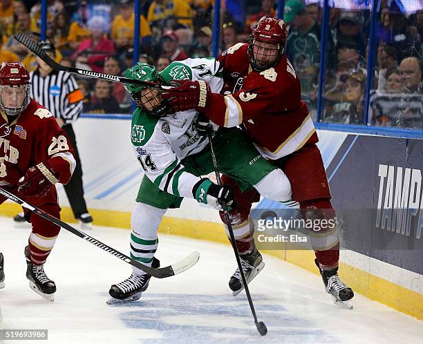 Austin Poganski of the North Dakota Fighting Hawks and Tariq Hammond of the Denver Pioneers fight for the puck in the first period during semifinals...