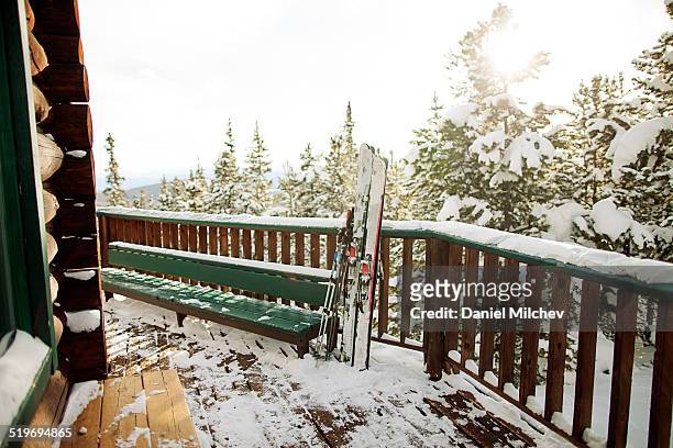 skis on the patio of a backcountry hut. - ballustrade stockfoto's en -beelden