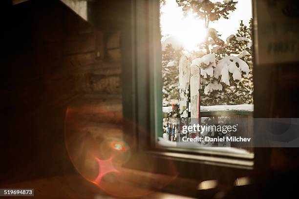 view of skis, out the window of a hut. - chalet de montagne photos et images de collection