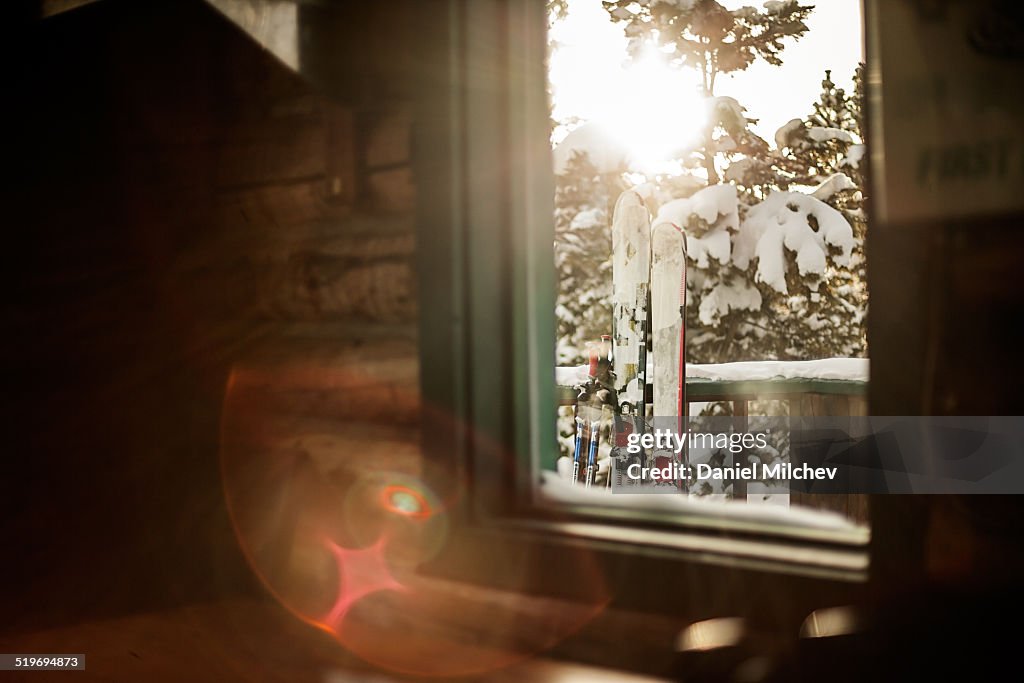 View of skis, out the window of a hut.