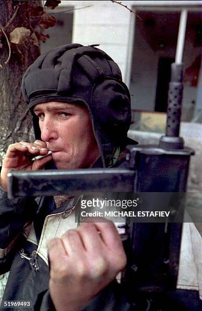 Chechen fighter holding a homemade automatic gun takes advantage of a pause in the shelling in downtown Grozny 13 December. Russian forces launched a...