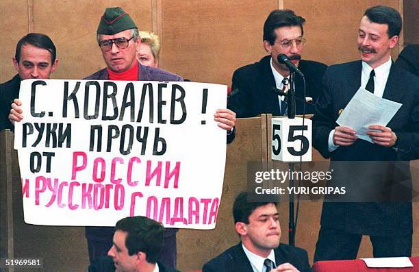 Viatchislav Marachev, a member of the nationalist Liberal Democratic Party, holds a poster critical of the President of the Human Rights Commission,...