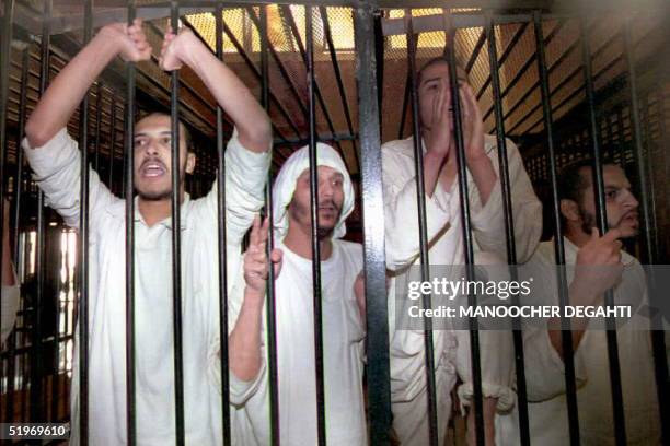 Islamic militants chant religious slogans 10 January from a jail cell in the military court in Haekstep, Egypt, north of Cairo, after they were...