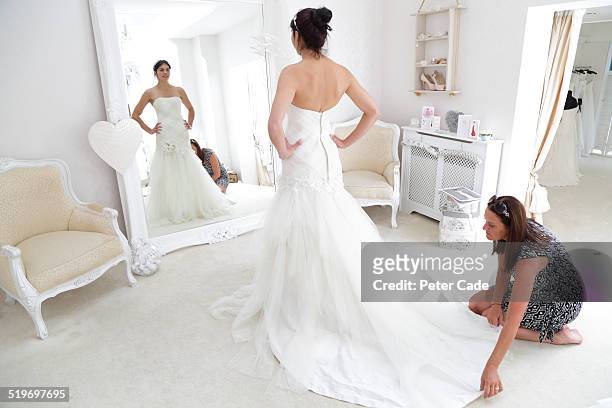 woman in bridal shop having a dress fitting. - bridal shop stock pictures, royalty-free photos & images
