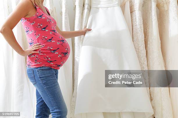 pregnant lady looking at wedding dresses - maternity wear stock pictures, royalty-free photos & images
