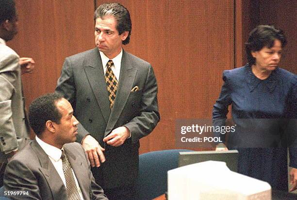 Murder defendant O.J. Simpson watches defense witness Rosa Lopez enter the court for a hearing on how her testimony will be heard 27 February....