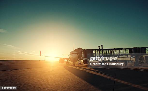 airplane in airport runway during sunset - einsteigen stock-fotos und bilder