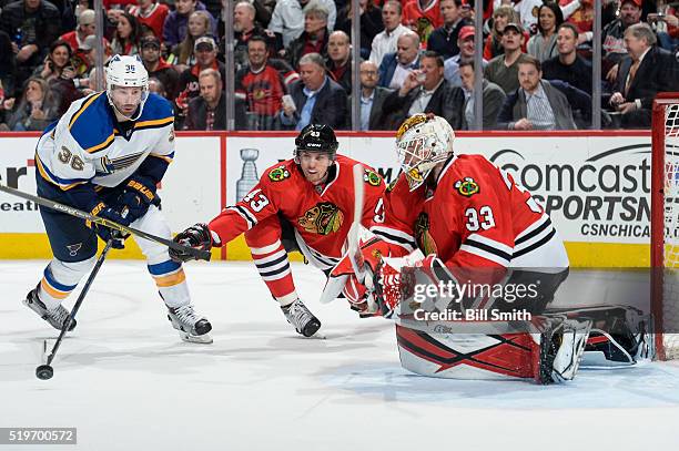 Viktor Svedberg of the Chicago Blackhawks reaches for the puck against Troy Brouwer of the St. Louis Blues, as goalie Scott Darling guards the net,...