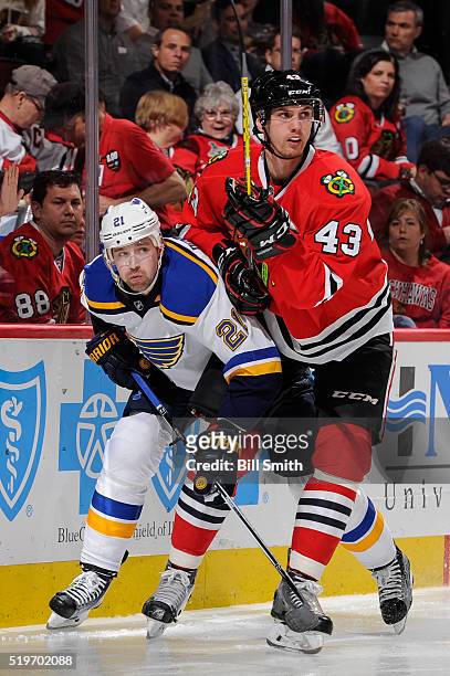 Patrik Berglund of the St. Louis Blues and Viktor Svedberg of the Chicago Blackhawks skate around the boards in the third period of the NHL game at...