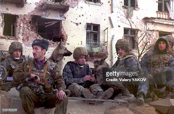 Russian Interior Ministry troops sit on an Armoured Personnel Carrier with their dogs in Grozny 15 February, where the situation reportedly remains...