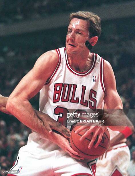 Chicago Bulls center Will Perdue wrestles a defensive rebound away from a Washington Bullets defender in the first half of their 15 February game at...