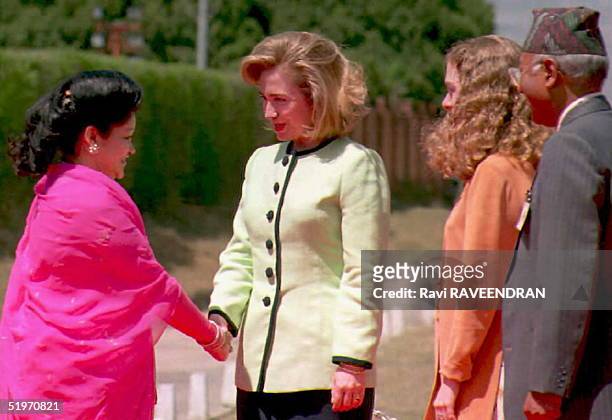 First Lady Hillary Clinton is greeted by Queen Aishworya of Nepal at the airport 31 March upon Mrs. Clinton's arrival for a three-day visit. At right...