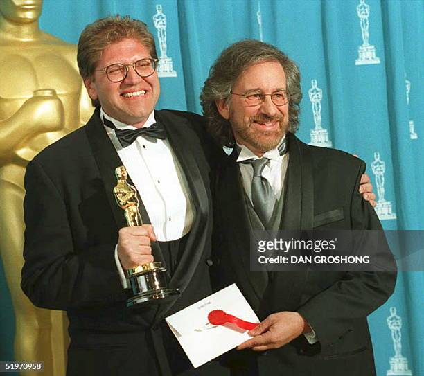 Director Robert Zemeckis holds the Oscar he won as best director for the film "Forrest Gump" as he poses with Steven Spielberg, who presented the...