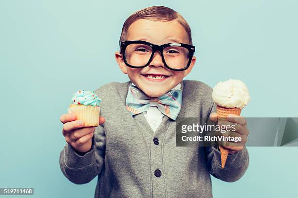 young nerd boy holds ice cream and cupcakes - indulgence stockfoto's en -beelden
