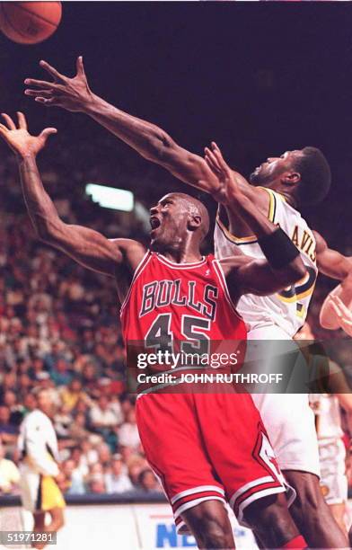 Chicago Bulls basketball star Michael Jordan makes a rebound against Indiana Pacers forward Antonio Davis in the first half, 19 March, at Market...