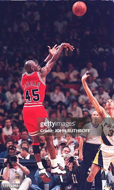 Chicago Bulls basketball star Michael Jordan takes one of his first shots as Indiana Pacers forward Reggie Miller watches in the first half 19 March...