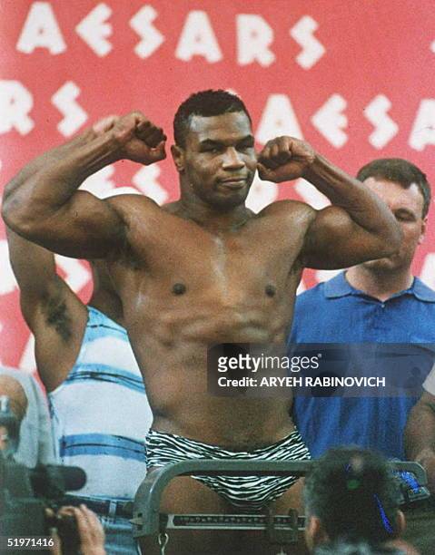 Mike Tyson, who is scheduled to be released from prison 25 March, strikes a pose 15 June 1990 during the weigh-in for his first heavyweight fight...