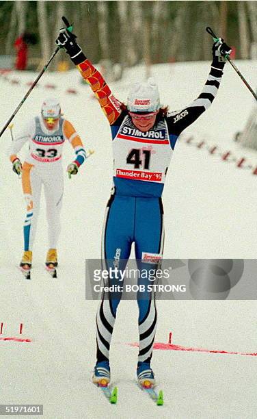 Russia's Larissa Lazutina celebrates as she crosses the finish line to win a gold medal in the women's 15 K classic at the World Nordic Ski...