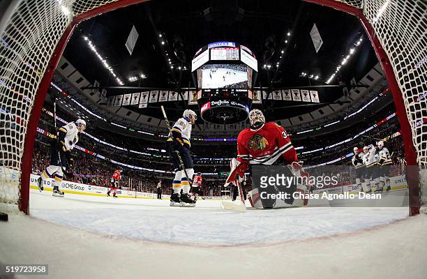 The St. Louis Blues celebrate behind goalie Scott Darling of the Chicago Blackhawks after the Blues tied it in the third period of the NHL game at...
