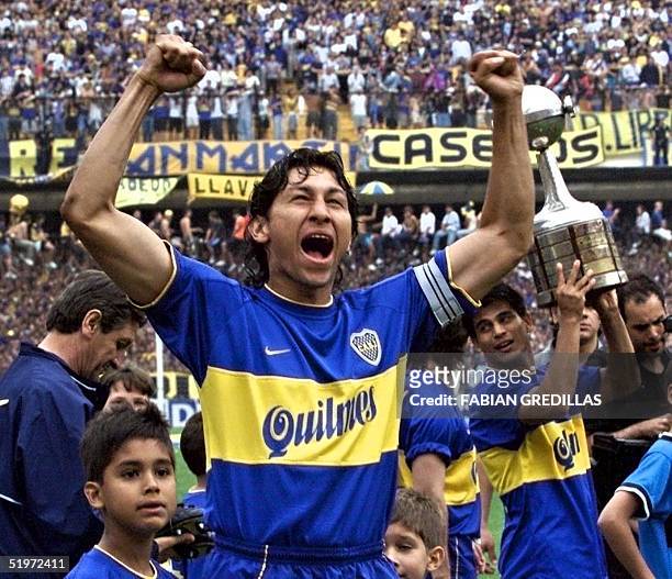 Boca Juniors soccer player, Colombian Jorge Bermudez celebrates 03 December 2000 with the winner trophy in the background. El futbolista de Boca...