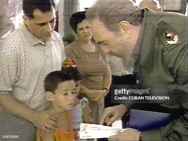 In this image taken 14 July 2000 for Cuban television and released 05 December 2000 in Havana, Cuban President Fidel Castro gives Elian Gonzalez the...