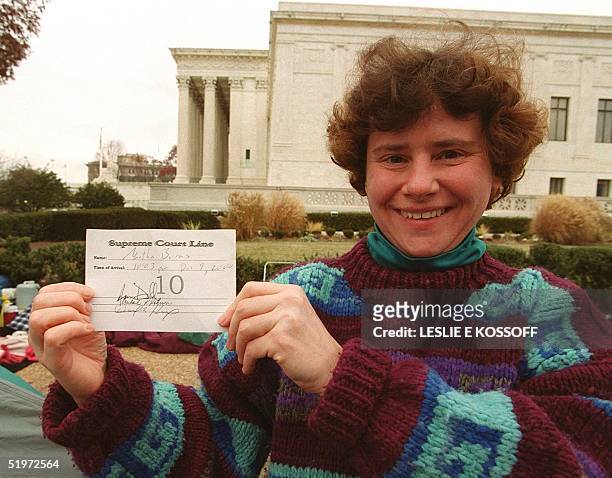 Martha Burns of Washington, DC, displays her ticket for her space in line at the US Supreme Court in Washington, DC, 10 December, 2000. The court...