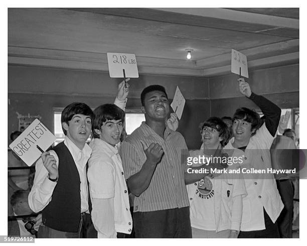 American heavyweight boxer Cassius Clay in a boxing ring with the Beatles at the 5th Street Gym, Miami, during the run-up to his title fight against...
