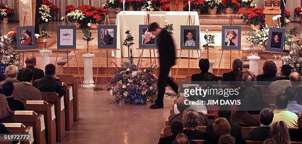 Brian Britney walks back to his seat after placing a flower next to the photograph of his partner, Paul Marceau -- a victim of the Edgewater...