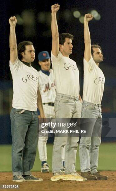 Three unidentified fans wearing shirts with the word "Greed" written on the front stand at second base in Shea Stadium after interrupting the New...