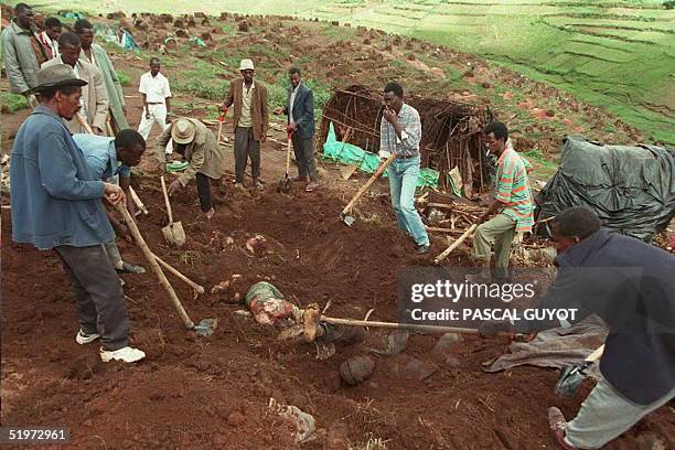 Workers exhume bodies from a mass grave at the Kibeho refugee camp 27 April to count the dead following the massacre of Hutu refugees allegedly...