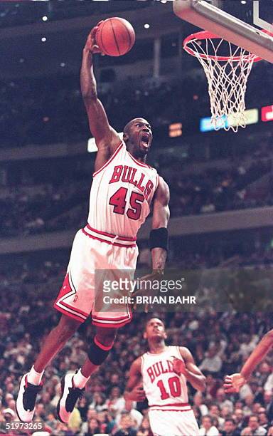 Michael Jordan of the Chicago Bulls cuts through traffic to dunk the ball in the third quarter 20 April against the Detroit Pistons at the United...