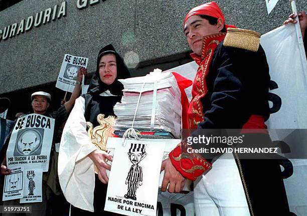 Un hombre disfrazado como Jose Maria Morelos, heroe mexicano de la independencia junto a una mujer disfrazada de Sor Juana Ines de la Cruz, famosa...