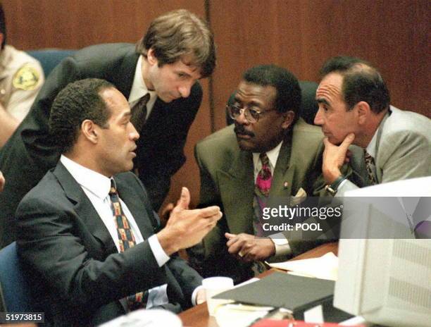 Murder defendant O.J. Simpson talks to his attorneys during their consultation about possible sanctions against the prosecution in regard to evidence...