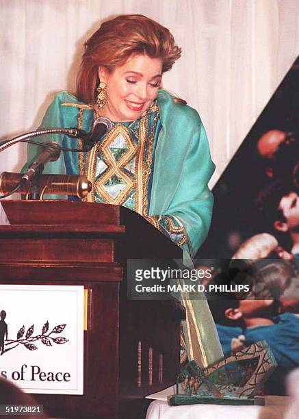 Jordan's Queen Noor Al Hussein reacts as a large photograph crashes to the floor from the wall behind her during her address to the Seeds of Peace...