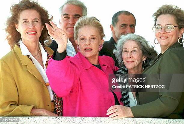French actress Jeanne Moreau salutes photographers as she is surrounded by members of the jury of the Cannes Film Festival, at the Cannes Festival...