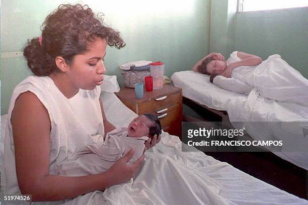 Mayra Ortiz acaricia a su bebe recien nacido mientras otra mujer amamanta al suyo en el Hospital de Maternidad en San Salvador,El Salvador. Cerca de...