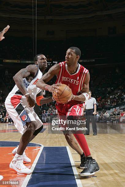Tracy McGrady of the Houston Rockets attempts to block Gerald Wallace of the Charlotte Bobcats during the game at Charlotte Arena on December 18,...